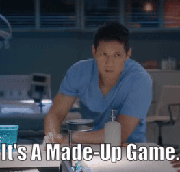 Man in Blue Shirt Sitting at Table Saying It's a Made-Up Game