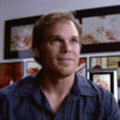 Man in Blue Shirt Sitting by Picture Wall