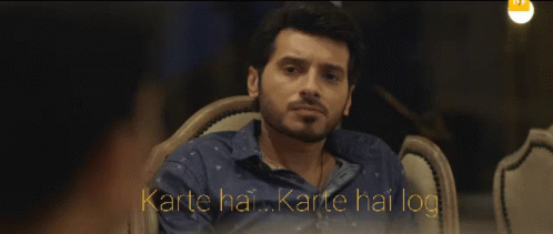 Man In Blue Shirt Sitting With Karte Hai Karte Hai Log GIF