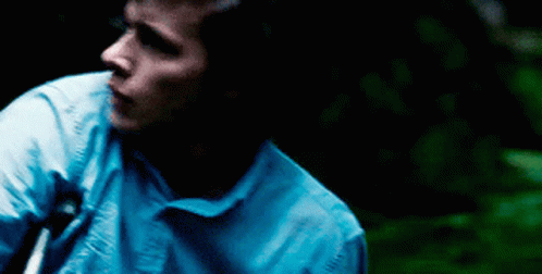 Man In Blue Shirt Standing In Darkness GIF