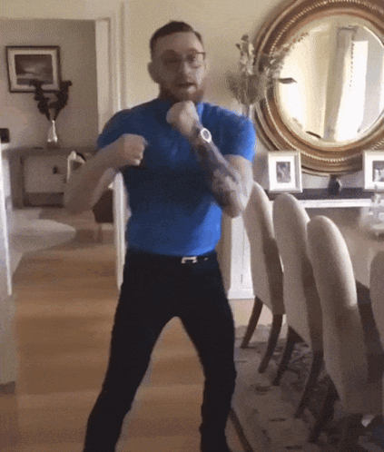 Man in Blue Shirt Standing in Front of Mirror