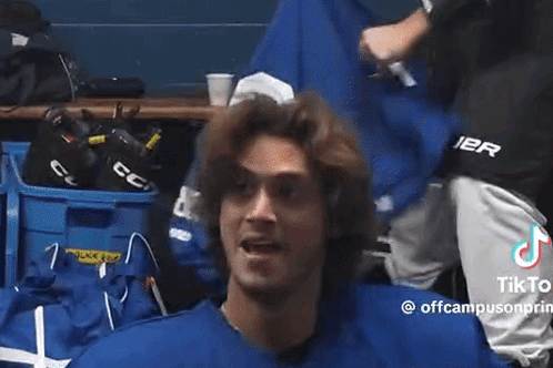 Man in Blue Shirt Standing in Locker Room