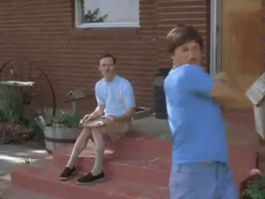 Man in Blue Shirt Standing on Steps With Sitting Man