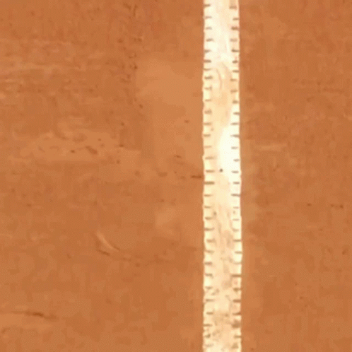 Man in Blue Shirt Standing on Tennis Court in Front of Isdin Sign