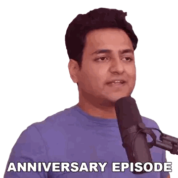 Man in Blue Shirt Talking Into Microphone
