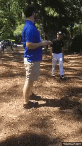 Man in Blue Shirt Talking on Dirt Path