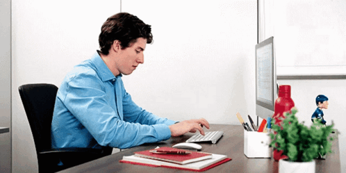 Man In Blue Shirt Typing At Desk GIF