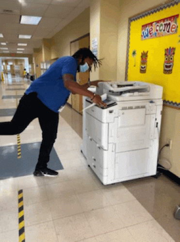 Man in Blue Shirt Using Copier