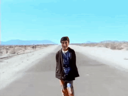 Man In Blue Shirt Walking Desert Road GIF
