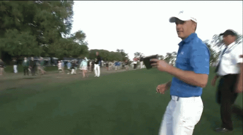 Man In Blue Shirt Walking On Golf Course GIF
