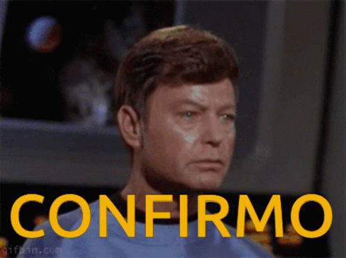 Man in Blue Shirt With Confirmo in Yellow Letters