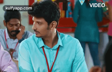Man in Blue Shirt with Lanyard Sitting