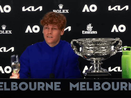 Man In Blue Shirt With Rolex And Emirates Ad GIF