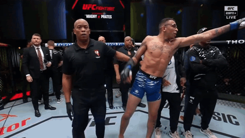 Man In Blue Shorts In Front Of UFC Sign GIF