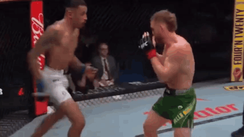 Man In Blue Shorts In Front Of UFC Sign GIF