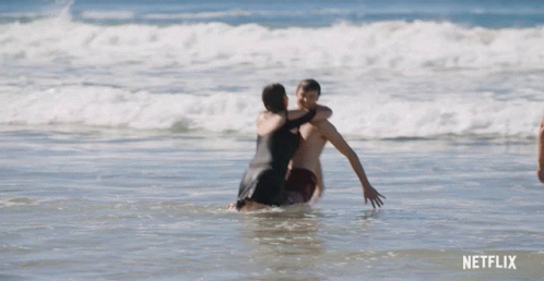 Man In Blue Shorts Standing In Ocean GIF
