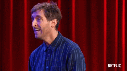Man In Blue Striped Shirt Clapping Before Red Curtain GIF