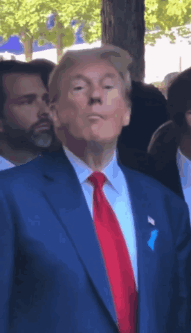 Man in Blue Suit and Red Tie in Crowd