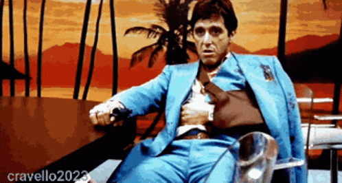 Man in Blue Suit Sitting by Palm Tree