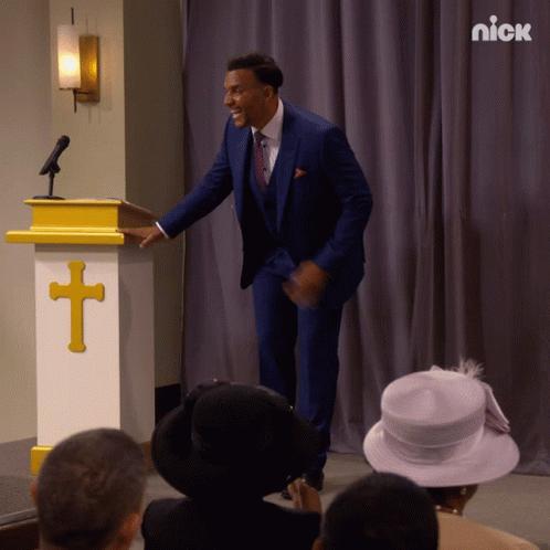 Man In Blue Suit Standing By Podium With Cross GIF