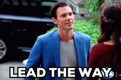 Man In Blue Suit Talks To Woman Saying Lead The Way GIF