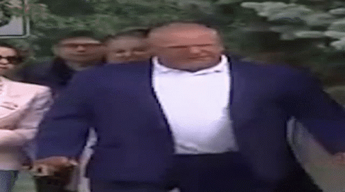 Man in Blue Suit White Shirt Walking With Group