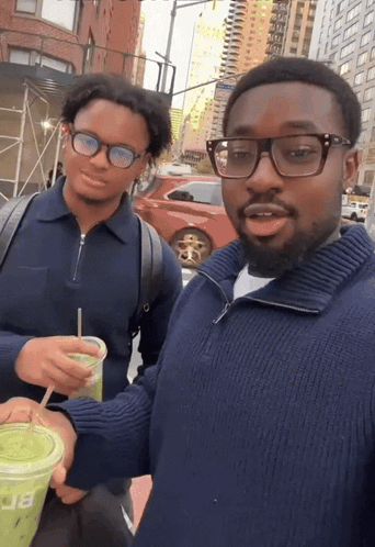 Man In Blue Sweater Holding Green Cup With Letter B GIF