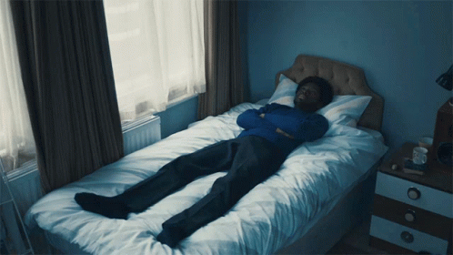 Man in Blue Sweater Lying on Bed