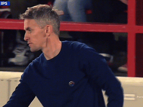 Man in Blue Sweater Red Fence Saying Ips