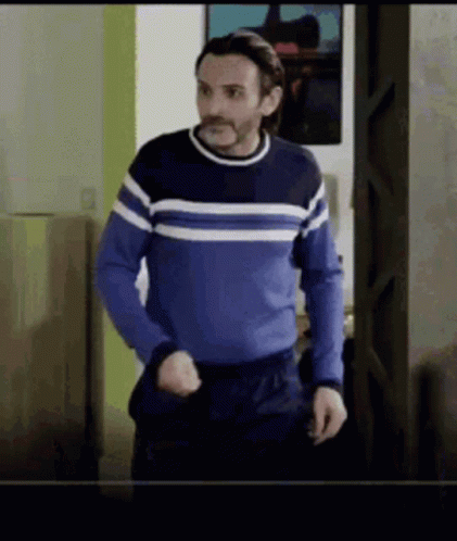 Man in Blue Sweater Standing in Doorway