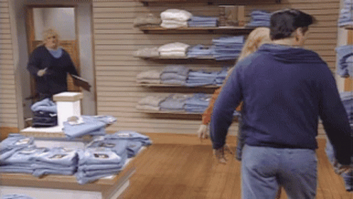 Man in Blue Sweatshirt Walking Through Store