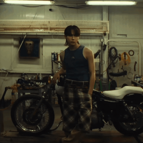 Man in Blue Tank Top in Front of Motorcycle