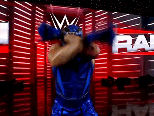 Man in Blue Wrestling Outfit with Raw on Red Wall