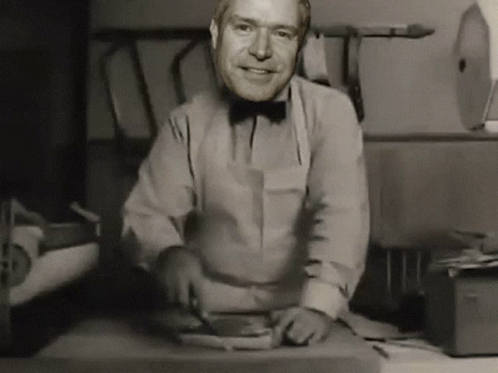 Man in Bow Tie Smiling While Cutting Meat