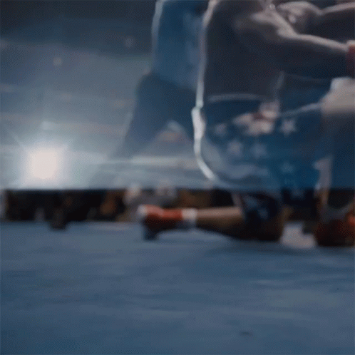 Man in Boxing Gloves Laying on Ground in Ring