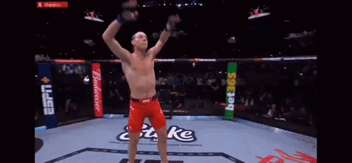 Man in Boxing Ring With Arms Up Saying Take