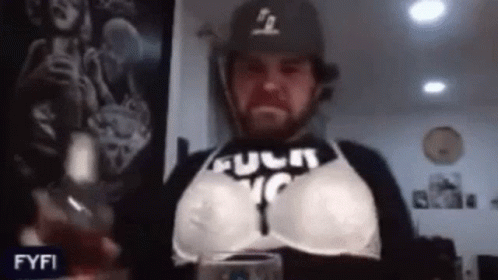 Man In Bra And Baseball Cap Holding Wine GIF
