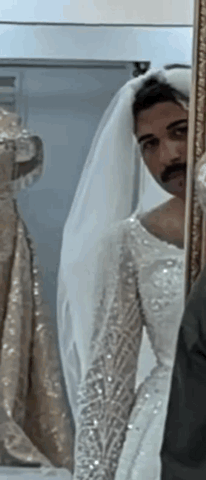 Man in Bride's Dress Looking in Mirror
