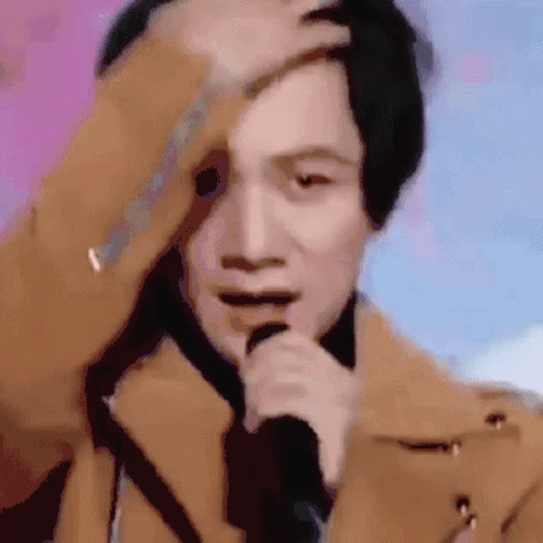 Man in Brown Coat Singing and Scratching Head