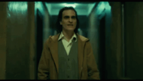Man in Brown Coat Standing in Dark Hallway