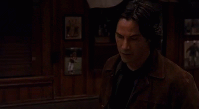 Man In Brown Jacket Beside Wall Portrait GIF