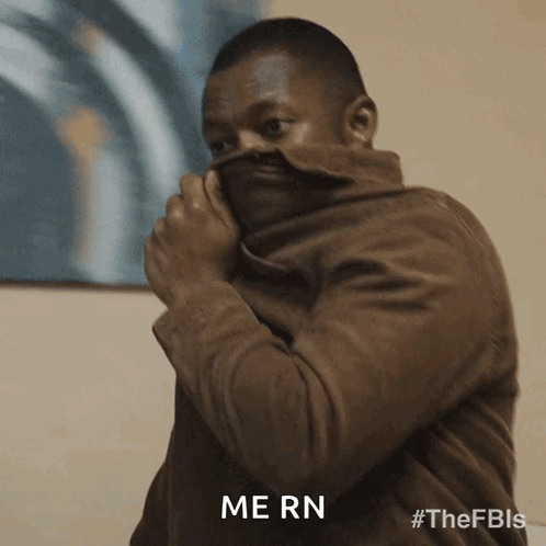 Man In Brown Jacket Covering Face With Jacket Saying Mern GIF