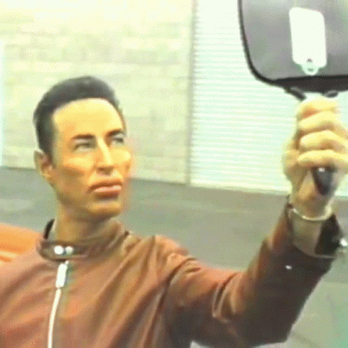 Man in Brown Jacket Holding Mirror