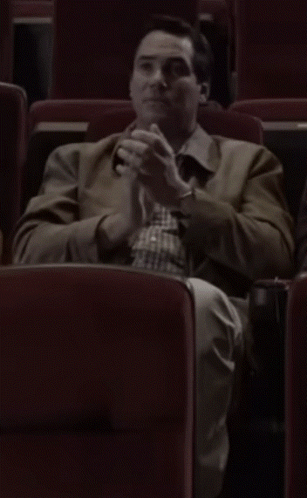 Man in Brown Jacket Sitting in Theater