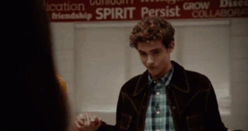 Man In Brown Jacket Standing In Front Of Spirit Persist Sign GIF