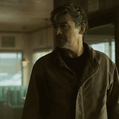 Man In Brown Jacket Standing In Room GIF