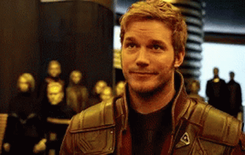 Man in Brown Leather Jacket Smiling with Statues