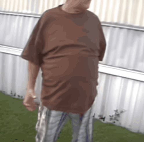 Man In Brown Shirt And Plaid Shorts GIF