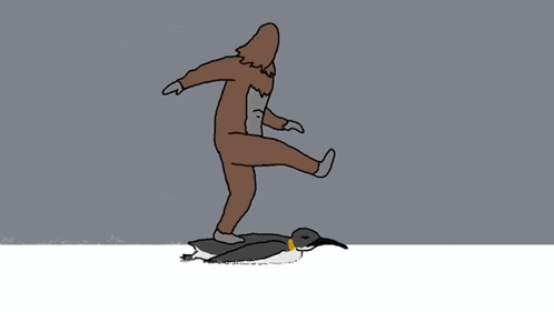 Man in Brown Suit Standing Next to Penguin