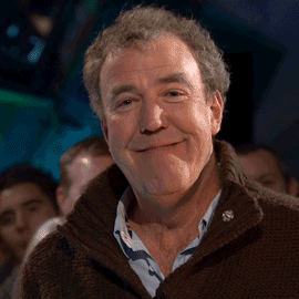 Man in Brown Sweater and Blue Shirt Smiling